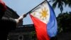 FILE - A protester waves a Philippine flag during a rally outside the Department of Foreign Affairs in Manila, Philippines on Friday, June 21, 2019.