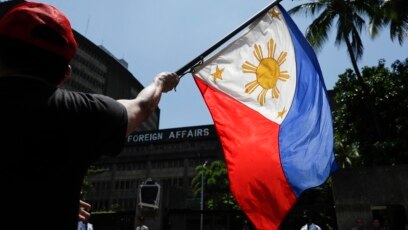Tư liệu: Một người biểu tình vẫy cờ Philippines tại cuộc tuần hành bên ngoài Bộ Ngoại giao ở Manila, 21/6/2019. TT Duterte gọi vụ tàu TQ đâm chìm một tàu cá Philippines là một 'tai nạn nhỏ.' 22 ngư phủ Philippines được tàu cá Việt Nam cứu vớt. (AP Photo/Aaron Favilla)