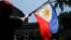 Tư liệu: Một người biểu tình vẫy cờ Philippines tại cuộc tuần hành bên ngoài Bộ Ngoại giao ở Manila, 21/6/2019. TT Duterte gọi vụ tàu TQ đâm chìm một tàu cá Philippines là một 'tai nạn nhỏ.' 22 ngư phủ Philippines được tàu cá Việt Nam cứu vớt. (AP Photo/Aaron Favilla)