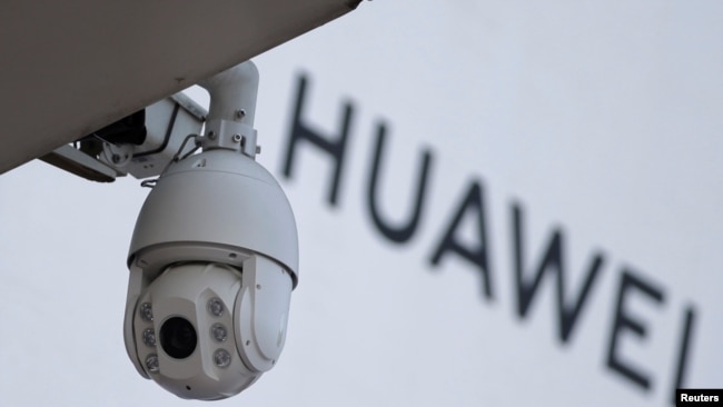 北京一家商场外的华为标志旁安装了一个监控摄像头。（2019年1月29日）