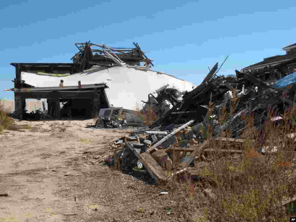 Pieces of an oceanfront home destroyed by Superstorm Sandy are scattered next to an existing home in Mantoloking N.J., Oct. 15, 2013.