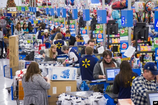 FILE - Sales clerks ring up customers at Walmart in Bentonville, Arkansas.