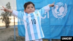 Murtaza Ahmadi posing with a jersey sent to him by Argentine football star Lionel Messi.