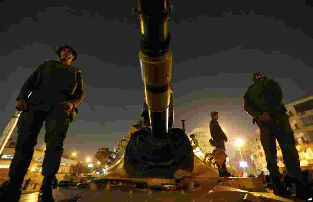 Soldiers stand guard on top of a tank in front of the presidential palace in Cairo, Egypt, December 9, 2012. 