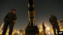 Binh sĩ Ai Cập đứng gác trên một chiếc xe tăng trước dinh tổng thống ở Cairo, ngày 9/12/2012.