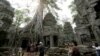 FILE - Tourists visit the Ta Prohm temple complex in Siem Reap province, Cambodia, on March 16, 2019.