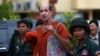 FILE - Australia filmmaker James Ricketson, center, ) speaks to the media at the Supreme Court in Phnom Penh, Cambodia, Jan. 17, 2018.