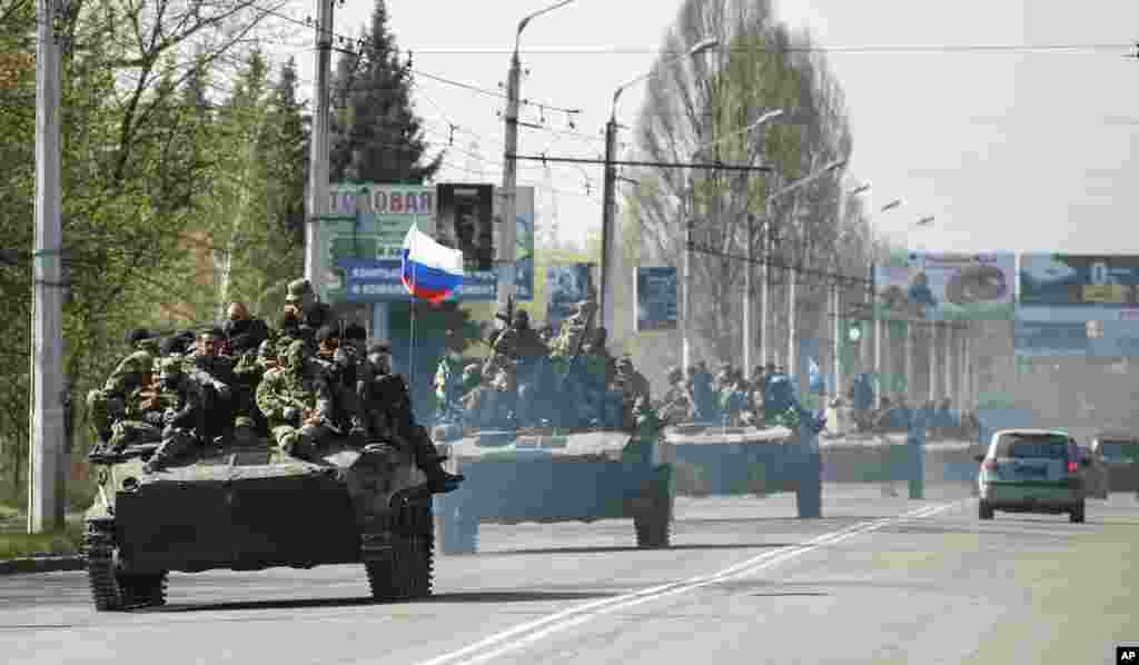 A column of combat vehicles with a Russian flag on the front one makes its way to the town of Kramatorsk, Ukraine, April 16, 2014. 