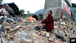 Seorang perempuan yang kerabatnya tewas akibat gempa menangis sambil duduk di atas tumpukan puing-puing di kotapraja Lingguan di kabupaten Baoxing, Provinsi Sichuan, China barat daya pada Minggu, 21 April 2013. (Foto: AP)