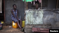Women sit on the porch of a house in the Congo Town neighborhood of Sierra Leone's capital Freetown, April 28, 2012. 