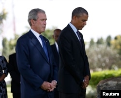 U.S. President Barack Obama and former President George W. Bush (R) attend a memorial for the victims of the 1998 U.S. Embassy bombing in Dar es Salaam, July 2, 2013.