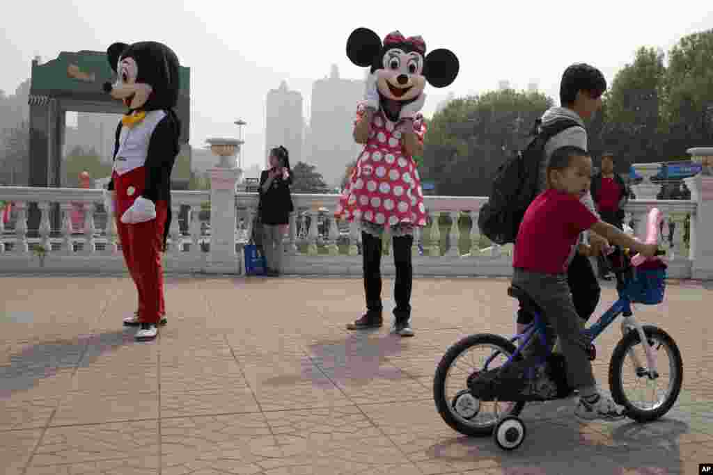 A Minnie Mouse look-alike mascot waits to greet visitors to a park in Beijing, China.