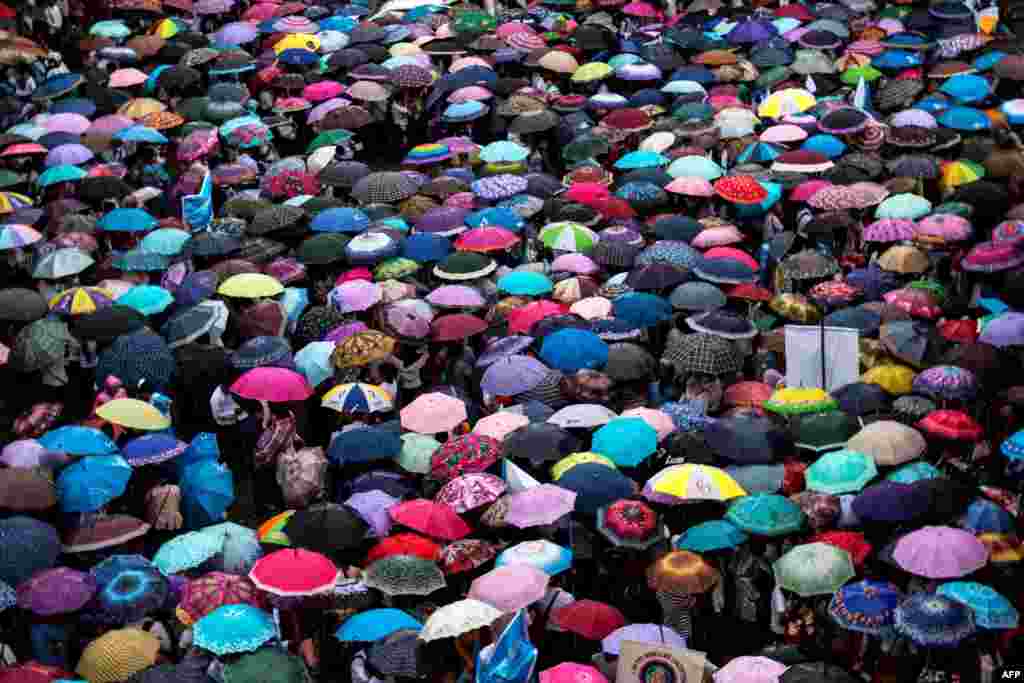 People cover themselves with umbrellas as they take part in a peace march under the rain in Myitkyina, Kachin state, Myanmar.