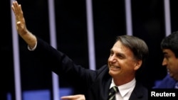 Brazil's President-elect Jair Bolsonaro waves during a session at the National Congress in Brasilia, Brazil, Nov. 6, 2018. 