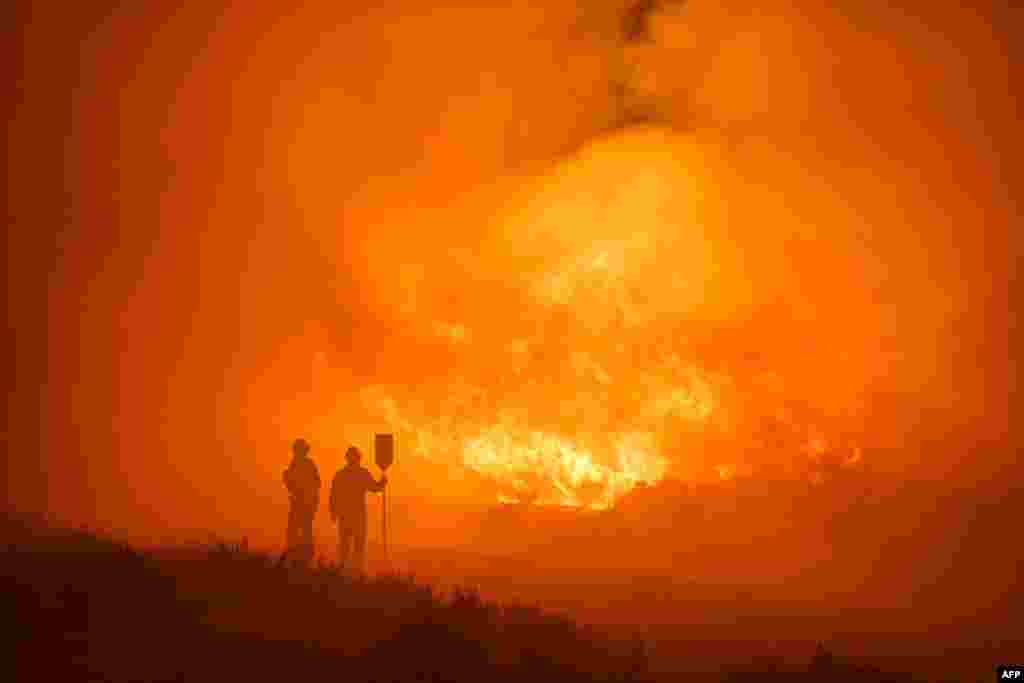 Firefighters operate at the site of a wildfire between Navalacruz and Riofrio near Avila, central Spain.