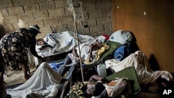 People suffering cholera symptoms rest on stretchers as they crowd the entrance of a public hospital in Limbe village near Cap Haitian, Haiti, 22 Nov 2010