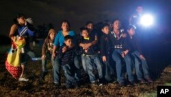 FILE - A group of young migrants from Honduras and El Salvador who crossed the U.S.-Mexico border illegally are stopped in Granjeno, Texas, June 25, 2014.