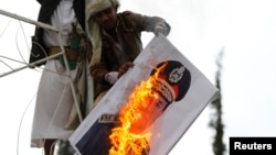 A pro-democracy protester burn an image of Lieutenant- General Abdel Fattah El Sisi, Egypt's Commanding General and Minister of Defense and Military Production, during a demonstration against what they said was a military coup that ousted Egyptian Preside
