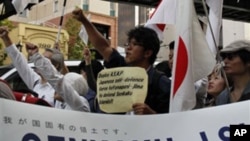 Japanese protesters spreading a banner with a message reading, "Senkaku Islands are Japanese Territories," march down streets in central Tokyo as an estimated 2,500 protesters take to the streets during a protest against China, 16 Oct 2010