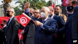 Leader of Tunisia's Islamist Ennahda party House Speaker Rached Ghannouchi waves a Tunisian flag during a rally in Tunis, Tunisia, Feb. 27, 2021. 