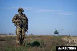 FILE - A Ukrainian serviceman secures an area in a Kyiv-controlled part of Donetsk region, eastern Ukraine, Oct. 14, 2019.