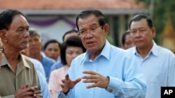 FILE: Cambodian Prime Minister Hun Sen, center, of ruling Cambodian People's Party speaks after his voting in the senate election at Takhmau polling station in Kandal province, southeast of Phnom Penh, Cambodia, Sunday, Feb. 25, 2018.