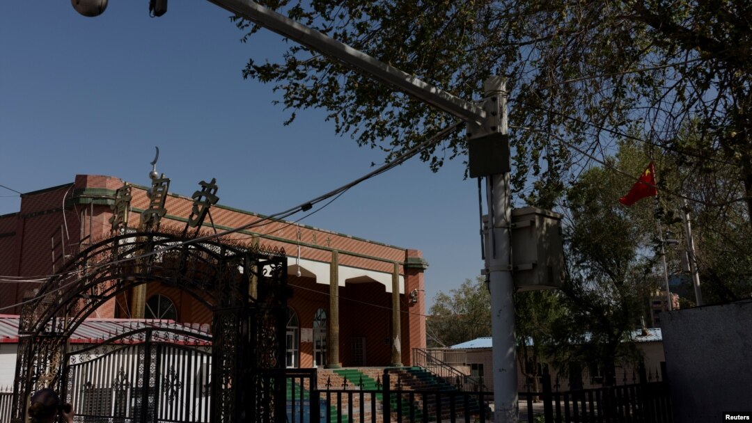 Bendera nasional China berkibar di luar bekas Masjid Xinqu yang kubah dan menaranya sudah dibongkar, di Changji, di luar Urumqi, Xinjiang, Uighur, China, 6 Mei 2021. (Foto: Thomas Peter/Reuters)