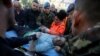 Military and emergency personnel helps an injured man in Thumane, after an earthquake shook Albania, Nov. 26, 2019.