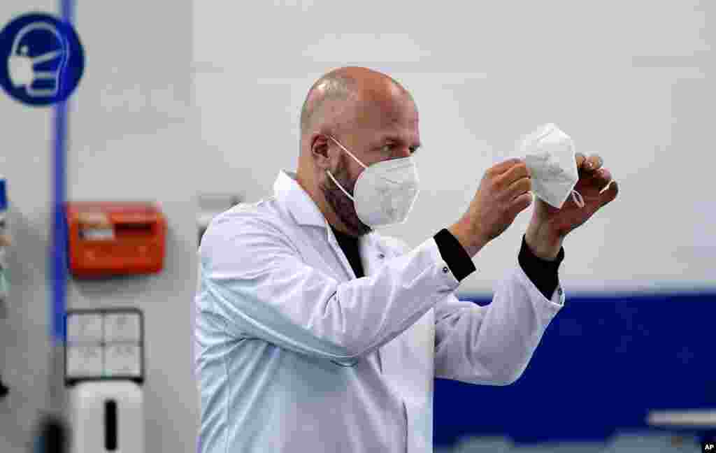 یک مدیر خط تولید کارخانه ماسک در آلمان بر کیفیت ماسک‌های تولیدی نظارت می‌کند. آلمان محدودیت‌های پیشگیری از کرونا مانند ماسک اجباری را تشدید کرده است.