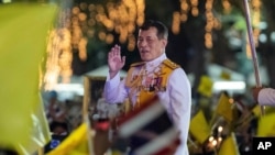 Thai King Maha Vajiralongkorn greets supporters as he walks to participate in a candle-lighting ceremony to mark the anniversary of the birth of late King Bhumibol Adulyadej, at Sanam Luang ceremonial ground in Bangkok, Thailand, Dec. 5, 2020.