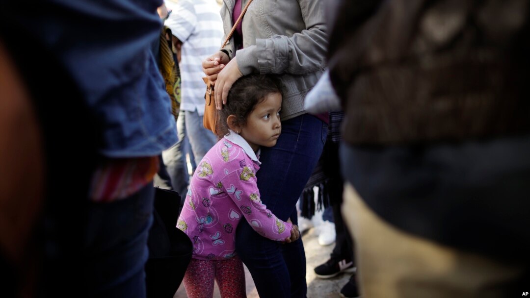 FILE - Nicole Hernandez, of the Mexican state of Guerrero, holds on to her mother as they wait with other families to request political asylum in the United States, across the border in Tijuana, Mexico, June 13, 2018.