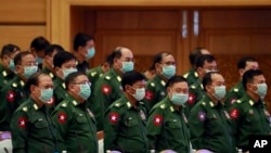 Military representatives stand upon arrival of Parliament Chairman T Khun Myat during a regular session of the Union Parliament Wednesday, March. 11, 2020, in Naypyitaw, Myanmar. 