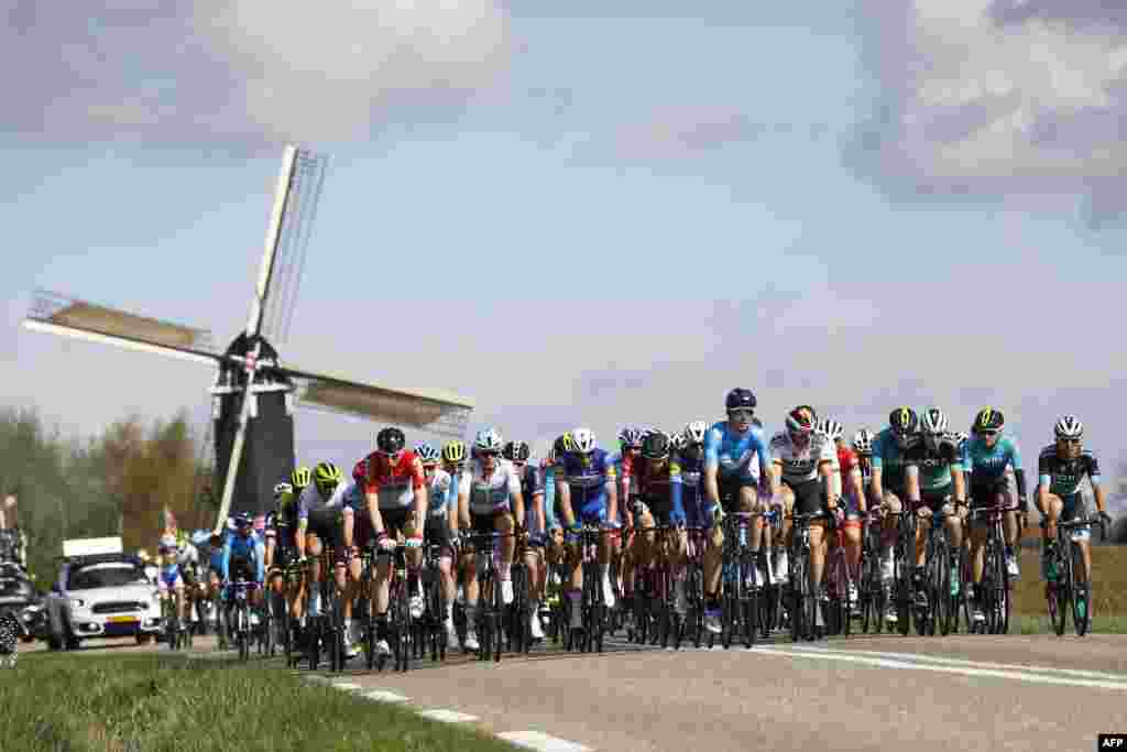 The pack rides past the Hubertus mill during the Amstel Gold Race in Beek, Netherlands.