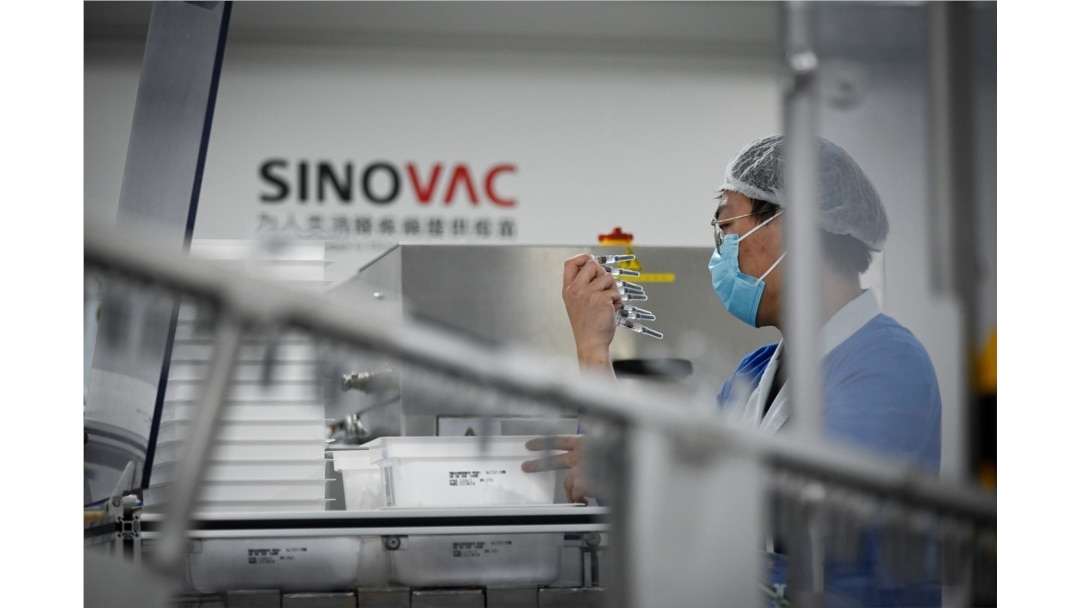 FILE - A staff member works during a media tour of a new factory built to produce a COVID-19 vaccine, at Sinovac, in Beijing, China, Sept. 24, 2020.