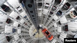 Mobil VW Golf VII (kanan) dan VW Passat diangkut dalam menara pengiriman di pabrik Volkswagen di Wolfsburg, Jerman (3/3). (Reuters/Fabian Bimmer)