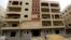 FILE - A man looks at a newly constructed residential building in El Maraj city at New Maadi, south of Cairo.