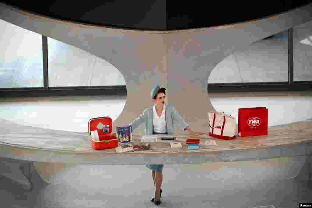 A worker stands behind a reception desk in the main lobby of the TWA Hotel, which is housed inside the former 1962 TWA Flight Center terminal, designed by architect Eero Saarinen, at JFK International Airport in New York, Oct. 2, 2019.