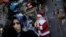 A woman walks past by a store selling New Year and Christmas ornaments in Istanbul, Turkey, Dec. 22, 2015. Turkey on Wednesday detained two suspected Islamic State members believed to be planning suicide attacks on New Year's celebrations in the country's capital.