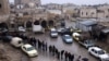 FILE - Former members of Syria's Bashar al-Assad's security forces wait in line to register for the identification and reconciliation process, after the ousting of al-Assad, in Aleppo, Syria, Dec. 23, 2024.