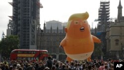 File - A six-meter high cartoon baby blimp of U.S. President Donald Trump is flown as a protest against his visit, in Parliament Square backdropped by the scaffolded Houses of Parliament and Big Ben in London, England, July 13, 2018.