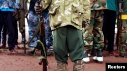 FILE - A former child soldier poses with his gun. According to UNICEF, an armed group fighting Boko Haram in Nigeria has released hundreds of child soldiers that had been recruited into its ranks.