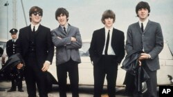 Los Beatles, de izquierda a derecha, John Lennon, George Harrison, Ringo Starr y Paul McCartney llegan a Liverpool, Inglaterra, el 10 de julio de 1964, para el estreno de su película "A Hard Day's Night".