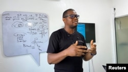 Samuel Anyaele teaches coding using a phone in Lagos, Nigeria, May 19, 2021. (REUTERS/Seun Sanni)