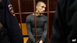 Russian performance artist Pyotr Pavlensky, seen in this Nov. 10, 2015 photo, sits in a court room before a hearing on his case in Moscow, Russia. He's convicted Thursday of vandalism for a pro-Ukraine protest and sentenced to 16 months in prison.