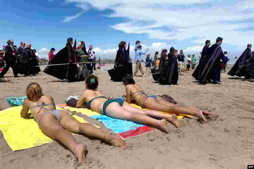 April 22: Penitents of the Santisimo Cristo del Salvador y el Amparo brotherhood take part in an Easter Holy Week procession in Valencia, Spain. (AP Photo/Alberto Saiz)