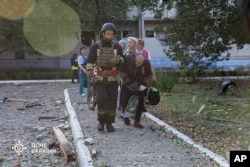 An aged  pistillate   is assisted by exigency  services unit   aft  a Russian onslaught   that deed  a location  for the aged  successful  Sumy, Ukraine, Sept. 19, 2024. (Ukraine's Emergency Service via AP)