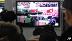 Warga Seoul, Korea Selatan menyaksikan siaran berita yang menampilkan cuplikan film tentang roket Korea Utara yang ikut dipamerkan dalam arak-arakan di sebuah parade militer (24/1). Korut mengancam akan menindak keras Korea Selatan jika Seoul terlibat langsung dalam resolusi PBB yang memperketat sanksi terhadap Pyongyang.