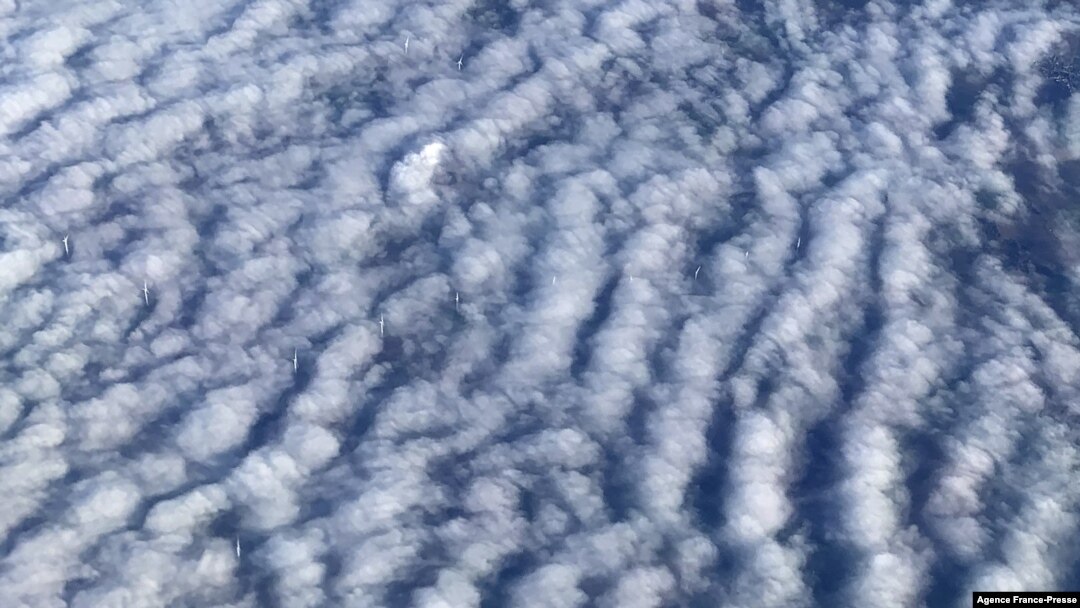 This picture taken from a plane shows wind turbines through stratocumulus clouds over Germany on December 7, 2021. 
