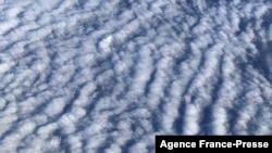 This picture taken from a plane shows wind turbines through stratocumulus clouds over Germany on December 7, 2021. 