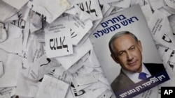 FILE - In this Wednesday, March 18, 2015 file photo, an election campaign poster with the image of Israeli Prime Minister Benjamin Netanyahu lies among ballot papers at his party's election headquarters, in Tel Aviv. 